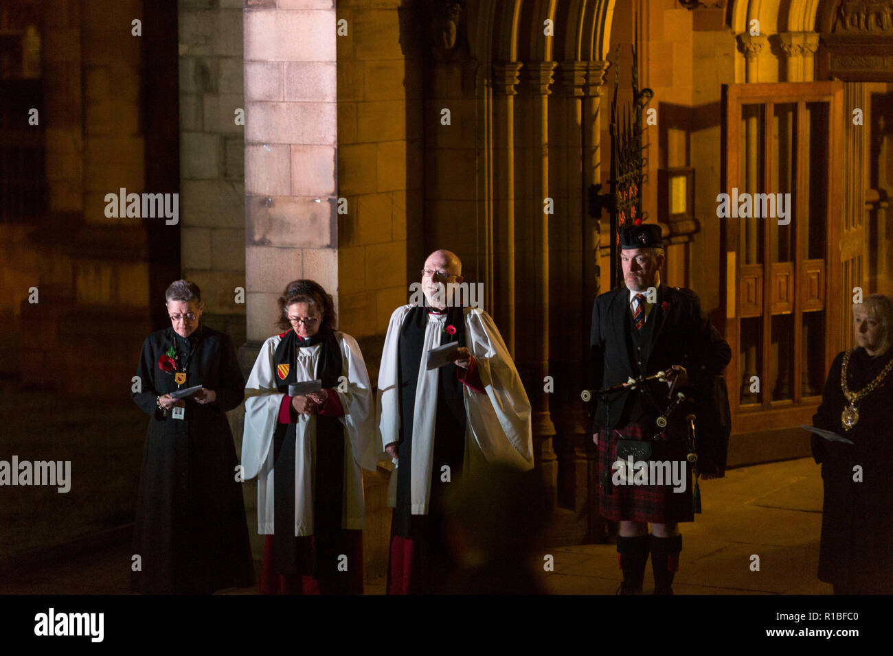Manchester , England , 11th November 2018  Armistice Day in Manchester. Today (Sunday 11 November) marks 100 years since the end of the First World War. At 6 a.m. a lone piper plays the traditional Scottish lament, Battle O'er, outside Manchester Cathedral to herald the start of commemorations. Canon David Holgate ,acting Dean of Manchester Cathedral  is pictured after the lament was played. Piper Neil Macdonald joined around 1,000 other pipers  across the UK and around the world playing at 6.00 a.m. Credit: Chris Bull/Alamy Live News. Stock Photo