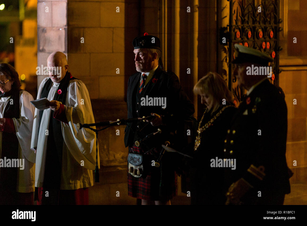 Manchester , England , 11th November 2018  Armistice Day in Manchester. Today (Sunday 11 November) marks 100 years since the end of the First World War. At 6 a.m. a lone piper plays the traditional Scottish lament, Battle O'er, outside Manchester Cathedral to herald the start of commemorations. Canon David Holgate ,acting Dean of Manchester Cathedral  is pictured after the lament was played. Piper Neil Macdonald joined around 1,000 other pipers  across the UK and around the world playing at 6.00 a.m. Credit: Chris Bull/Alamy Live News. Stock Photo