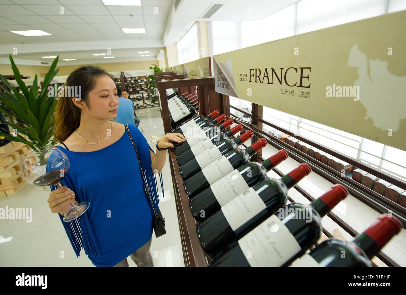 Beijing, China. 2nd Sep, 2012. A woman looks at red wine imported from France at the first Chongqing international red wine cultural festival in Chongqing, southwest China, Sept. 2, 2012. Credit: Liu Chan/Xinhua/Alamy Live News Stock Photo