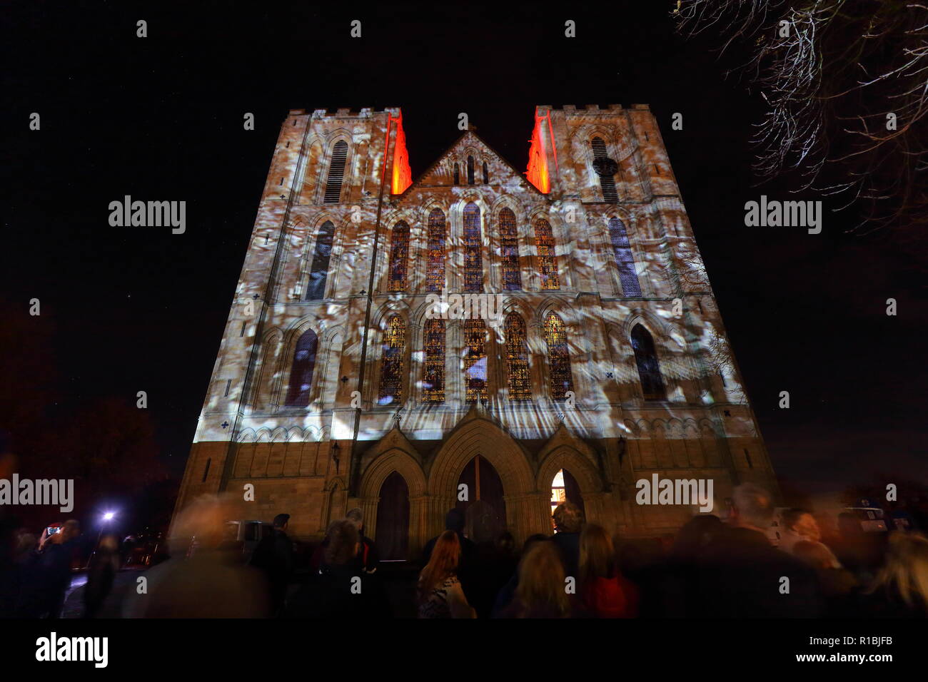 Ripon,North Yorkshire,UK. 10th November 2018. Ripon Cathedral puts on an illuminated projection display to mark armistice day 2018. The display shows still images from the war along with names of some of those who lost their lives. Animated poppies also cascade down the face of the cathedral where 1000's gathered to watch the final showing. Credit: Yorkshire Pics/Alamy Live News Stock Photo
