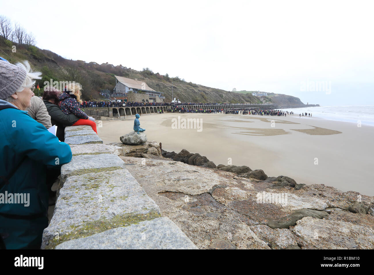 Folkestone, Kent, UK. 11th Nov, 2018. War poet Wilfred Own's face finally emerged from the beach at Sunny Sands as the sun came out. Danny Boyle arrived to join the 100s of people gathered to commemorate the Armistice Centenary. Credit: Monica Wells/Alamy Live News Stock Photo