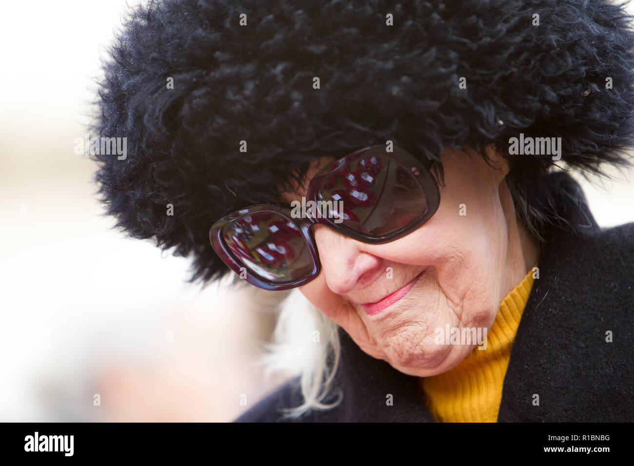 Cheltenham, Gloucestershire, UK.  11th November 2018. A lady views the poppy wreaths on the war memorial during the Remembrance day commemorations on the centenary of the Armistice for the first World War. © Steve Taylor / Alamy Live News Stock Photo