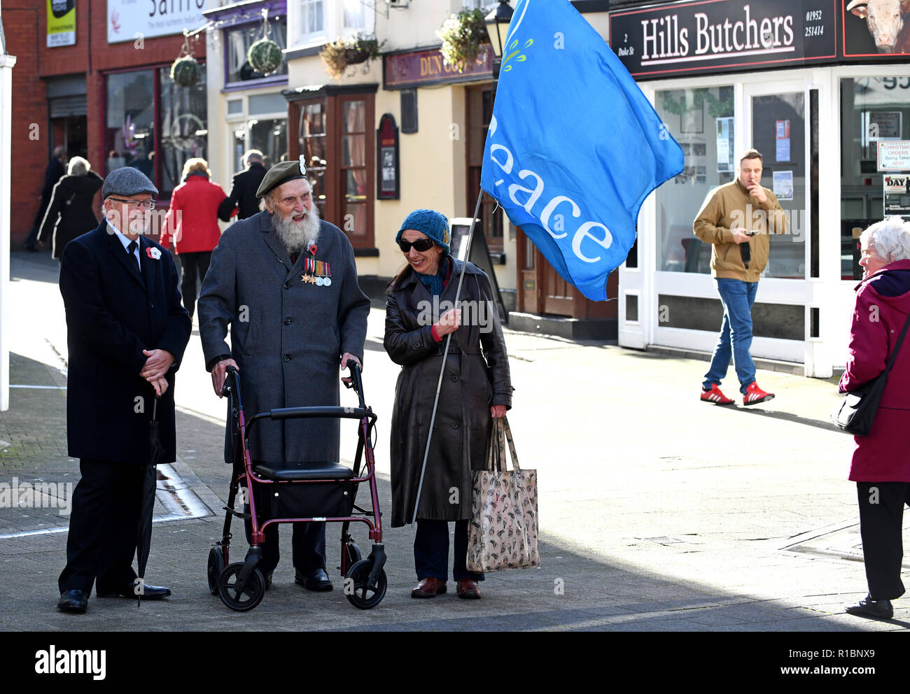 Wellington, Telford, UK. 11th Nov 2018. World War Two veteran George Evans aged 95 wearing red poppy and white peace poppy while flying the flag for 'Peace' at Wellington Remembrance Service a Parade Credit: David Bagnall/Alamy Live News Stock Photo