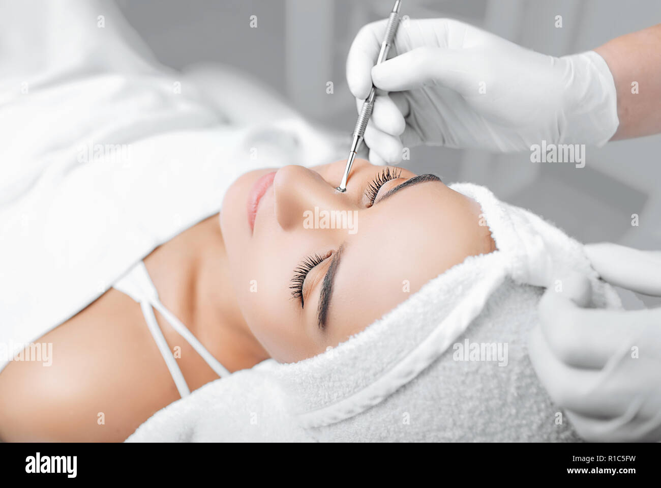 Beautician doing mechanical facial cleansing, procedure for cleansing pores and skin from defects Stock Photo