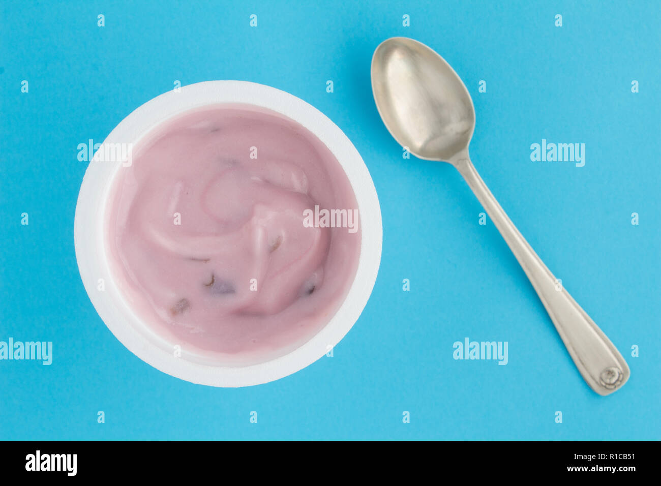 Yogurt cup with strawberry yoghurt in small plastic cup and vintage