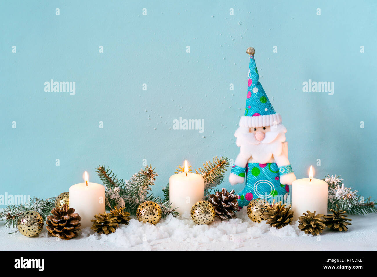 Christmas blue composition. Candles and a dwarf among fir branches Stock Photo