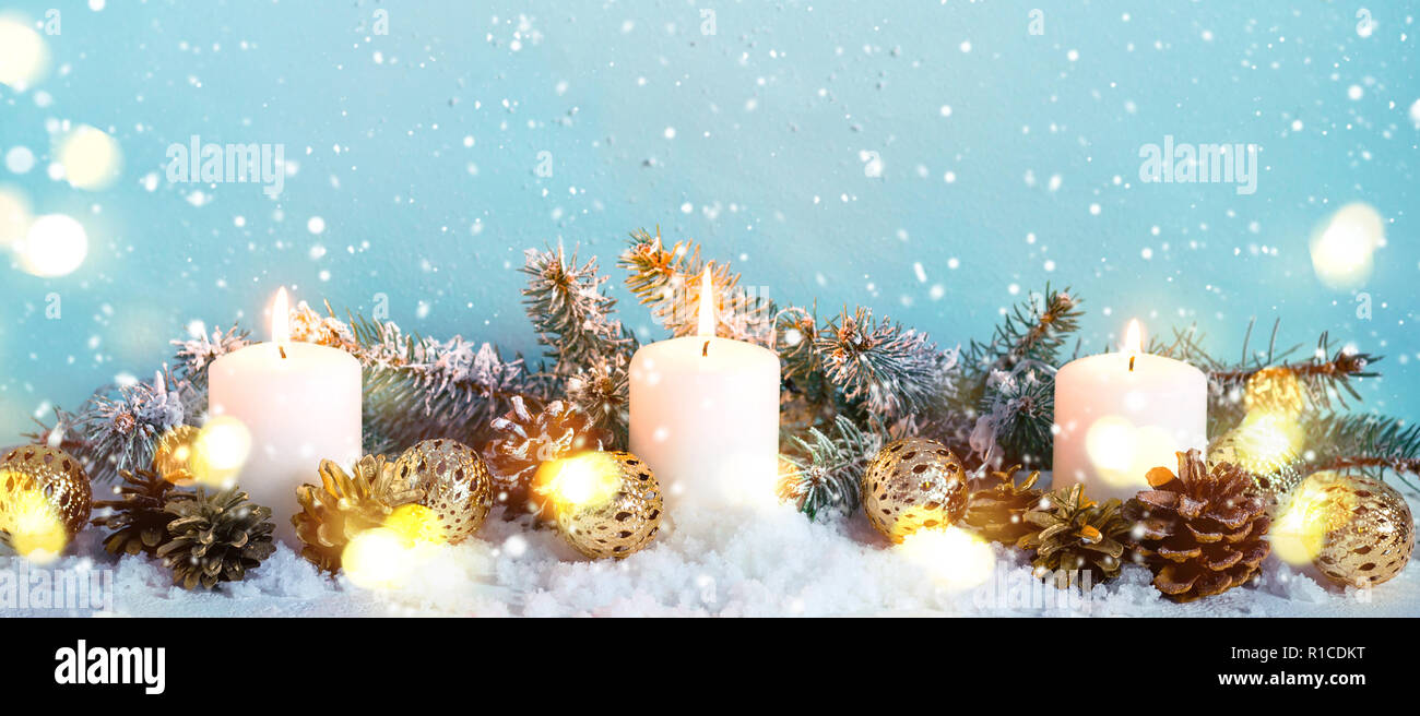 Blue snow Christmas Border of fir branches and burning candles. Stock Photo