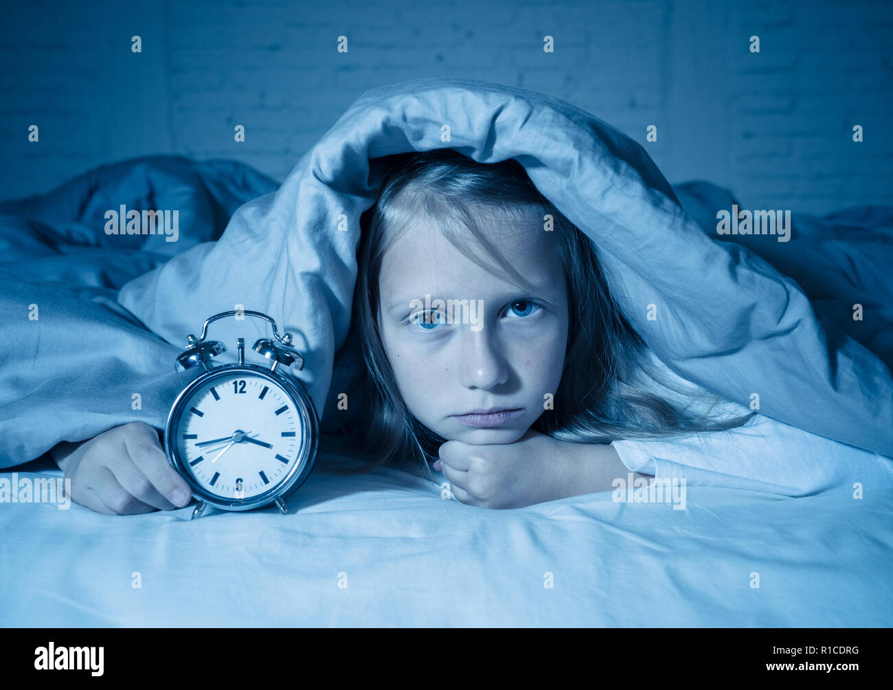 Cute sleepless little girl in bed awake in the middle of the night ...