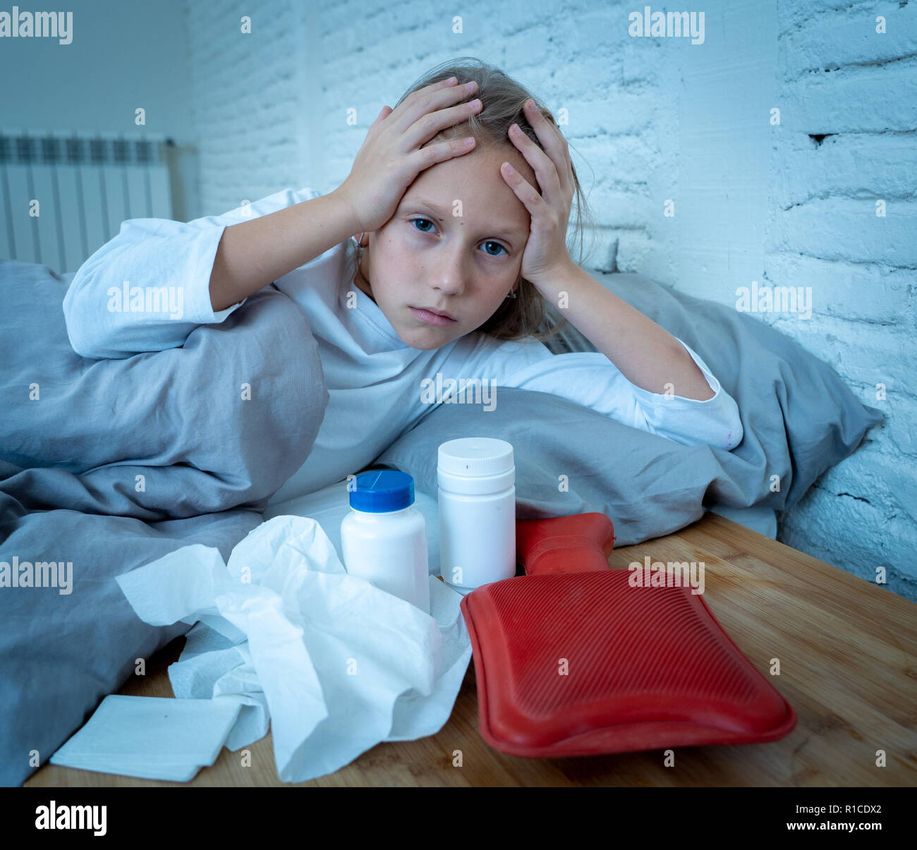 Cute sick girl in pain with high fever and headache feeling ill lying