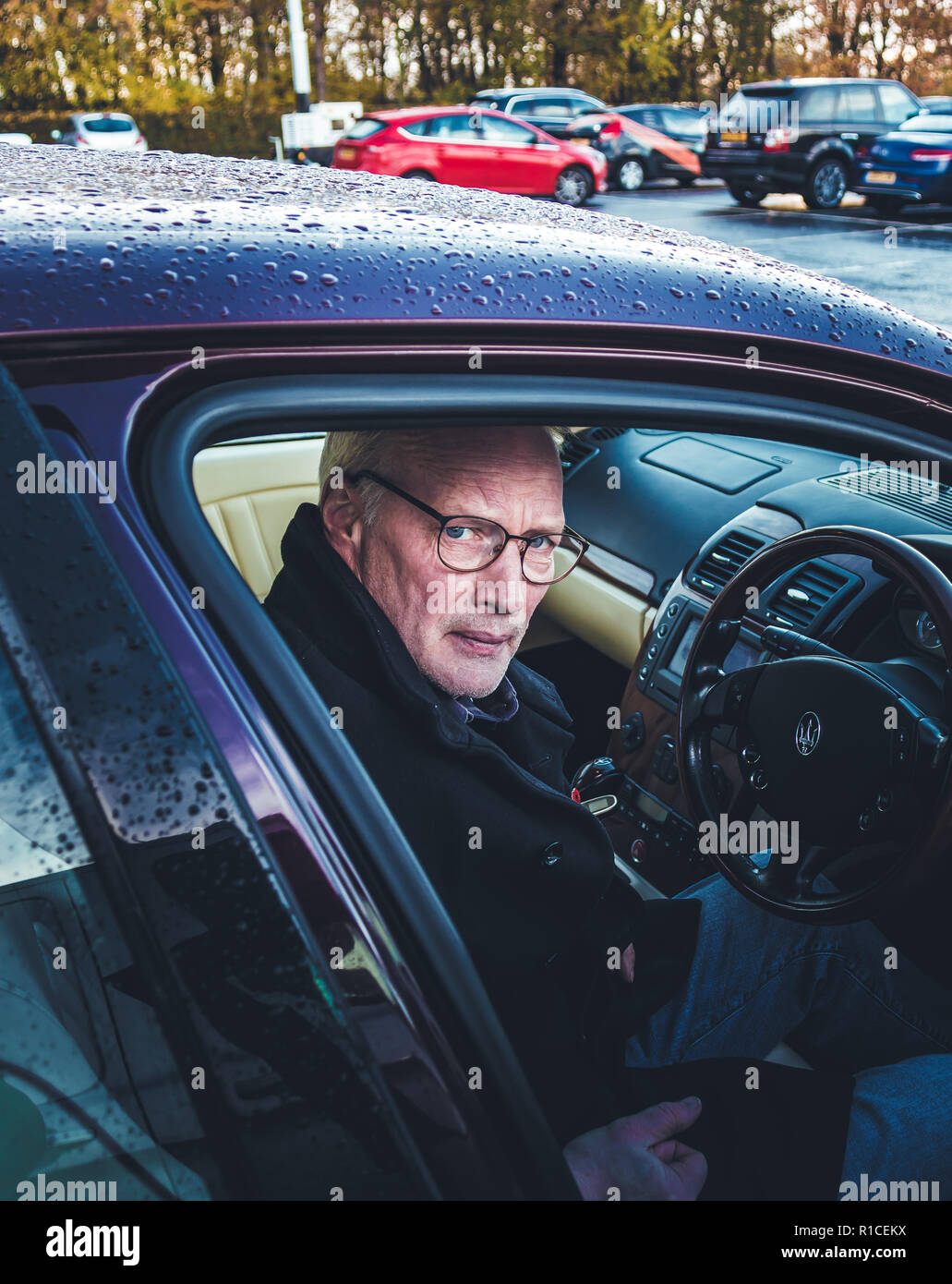 A middle age man sitting in a car, looking angry. Stock Photo