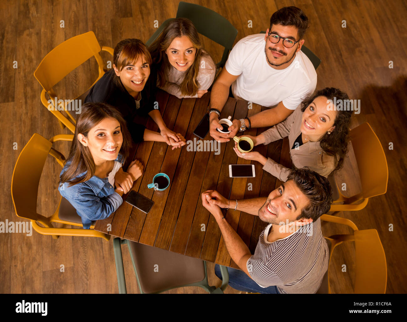 A group of friends drinking coffee at the cafe and looking up Stock Photo