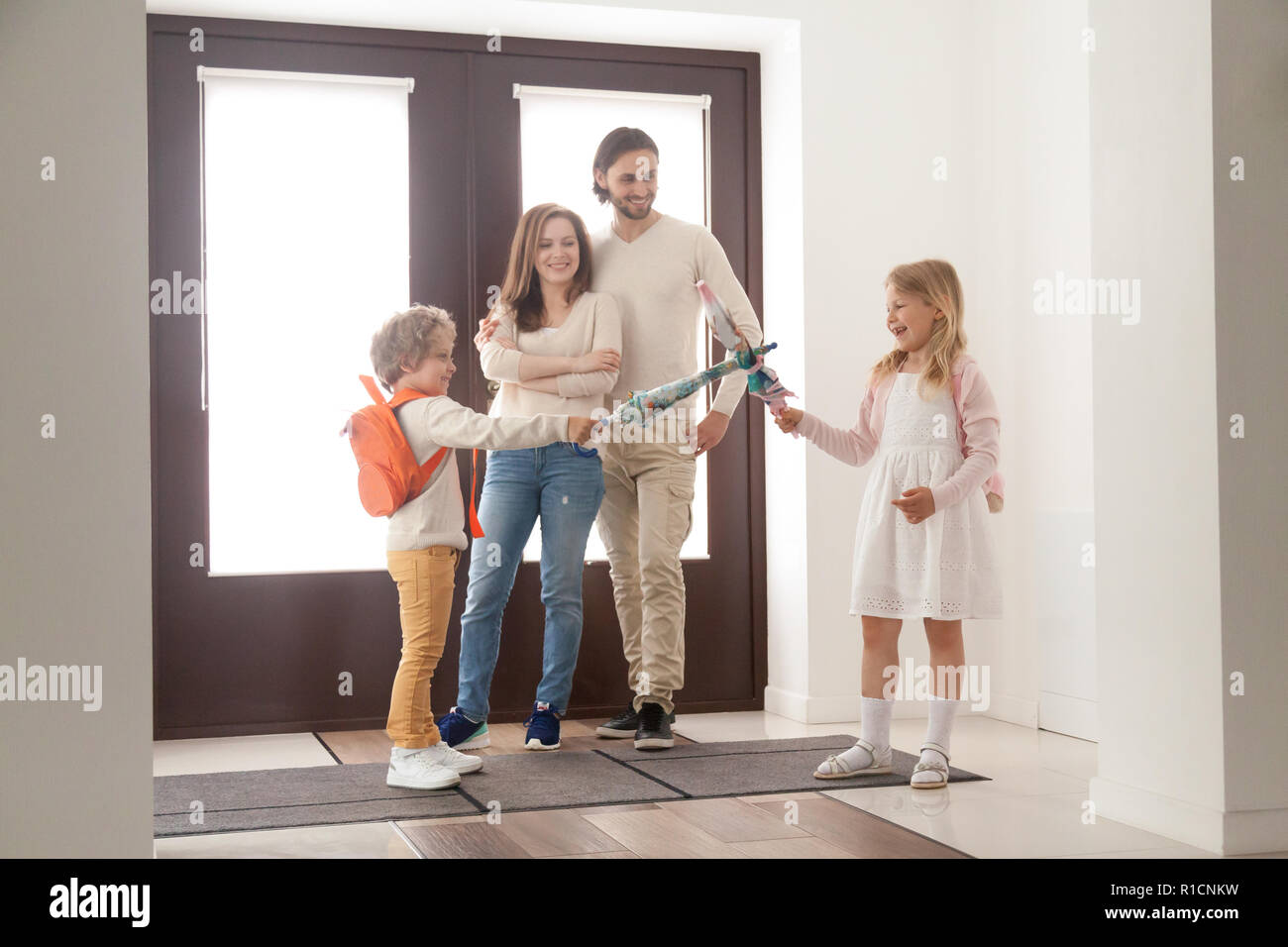Married couple with playful children in hallway at home Stock Photo