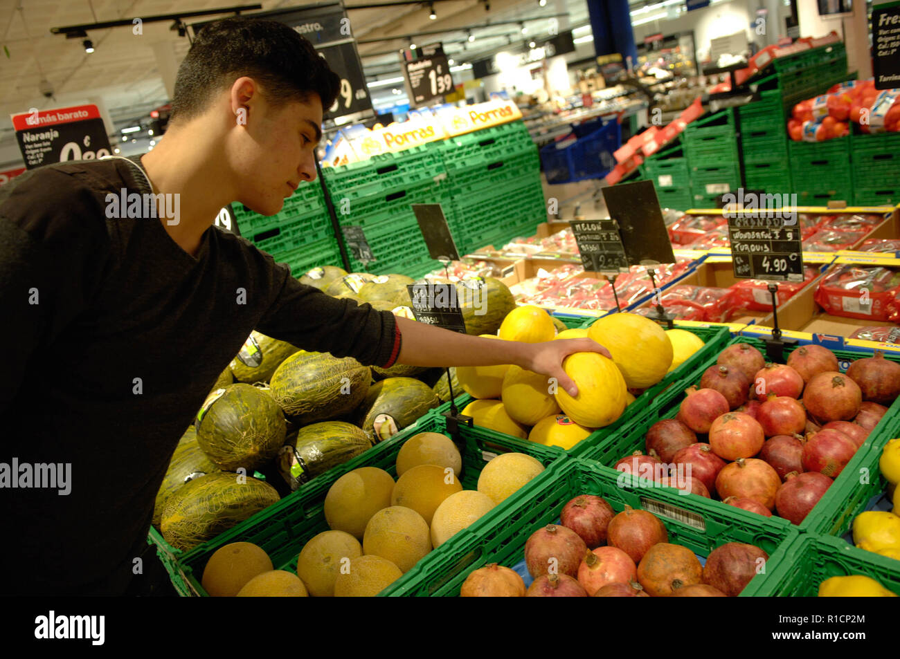 A Boy Picking Up A Melon In Supermarket Stock Photo Alamy
