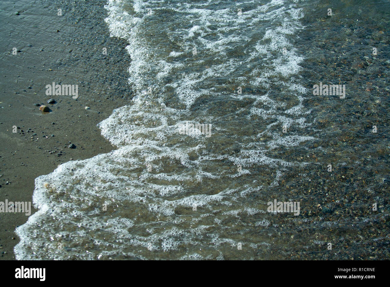 Stone beach with waves. Multi colore stones on beach Stock Photo