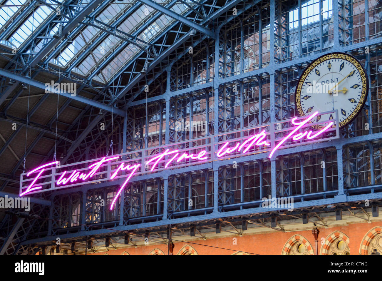 Tracey Emin's pink neon installation I Want My Time With You neon signage next to the world famous Dent clock face at St Pancras Station, London, UK Stock Photo