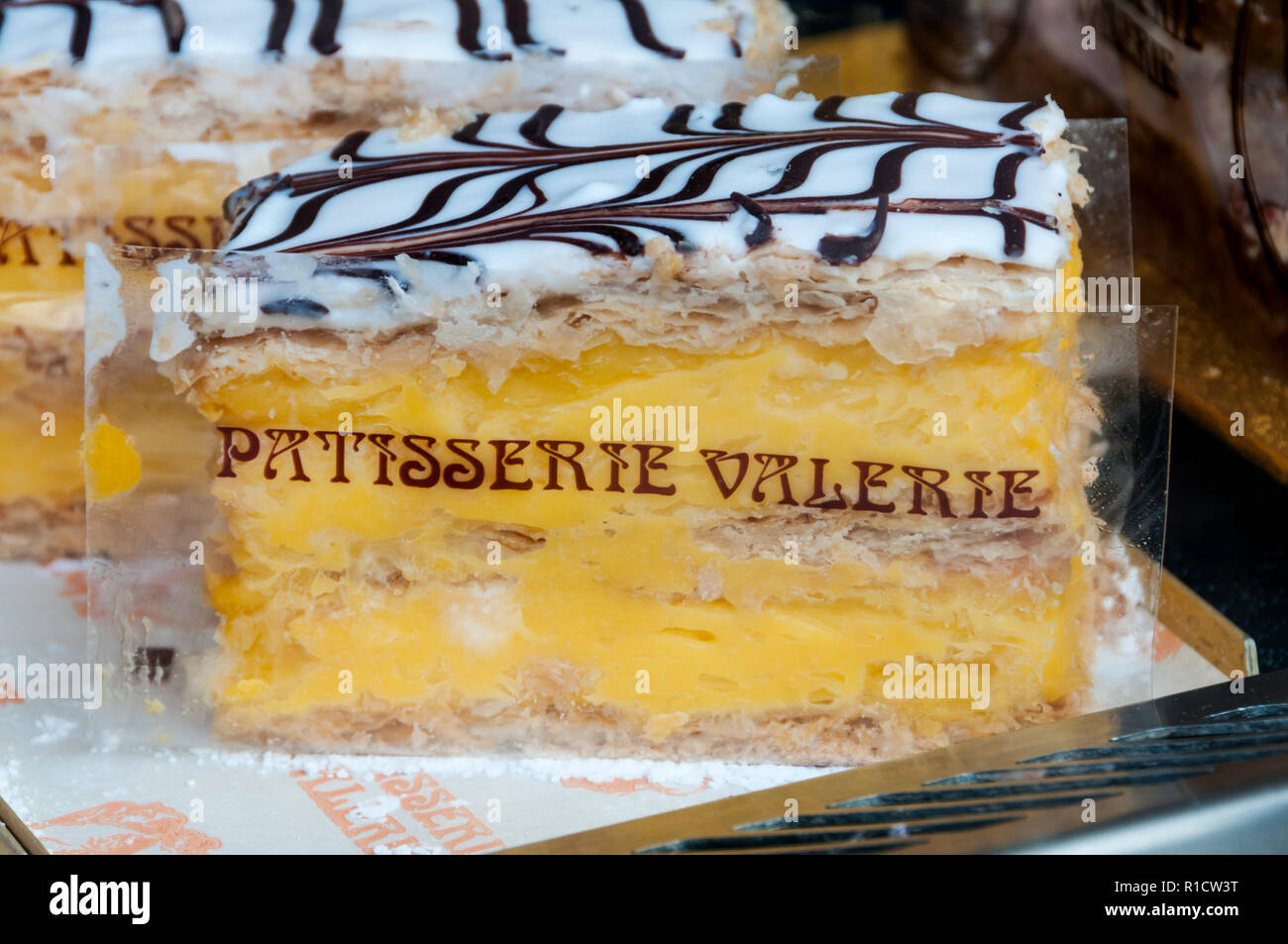 A cream slice in a shop window with the name of Patisserie Valerie on the wrapping. Stock Photo