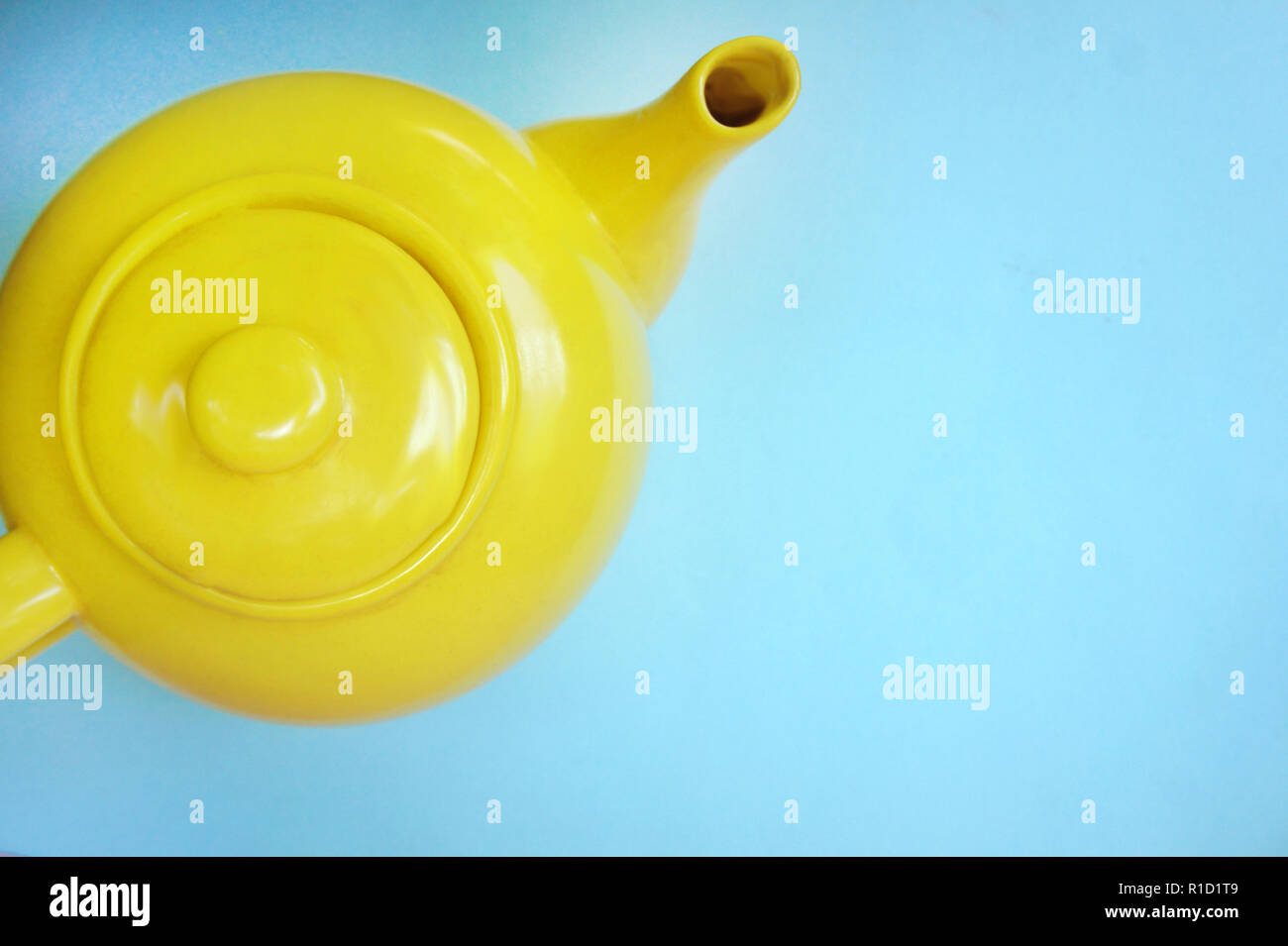 teapot on pastel blue background in modern design concept. yellow