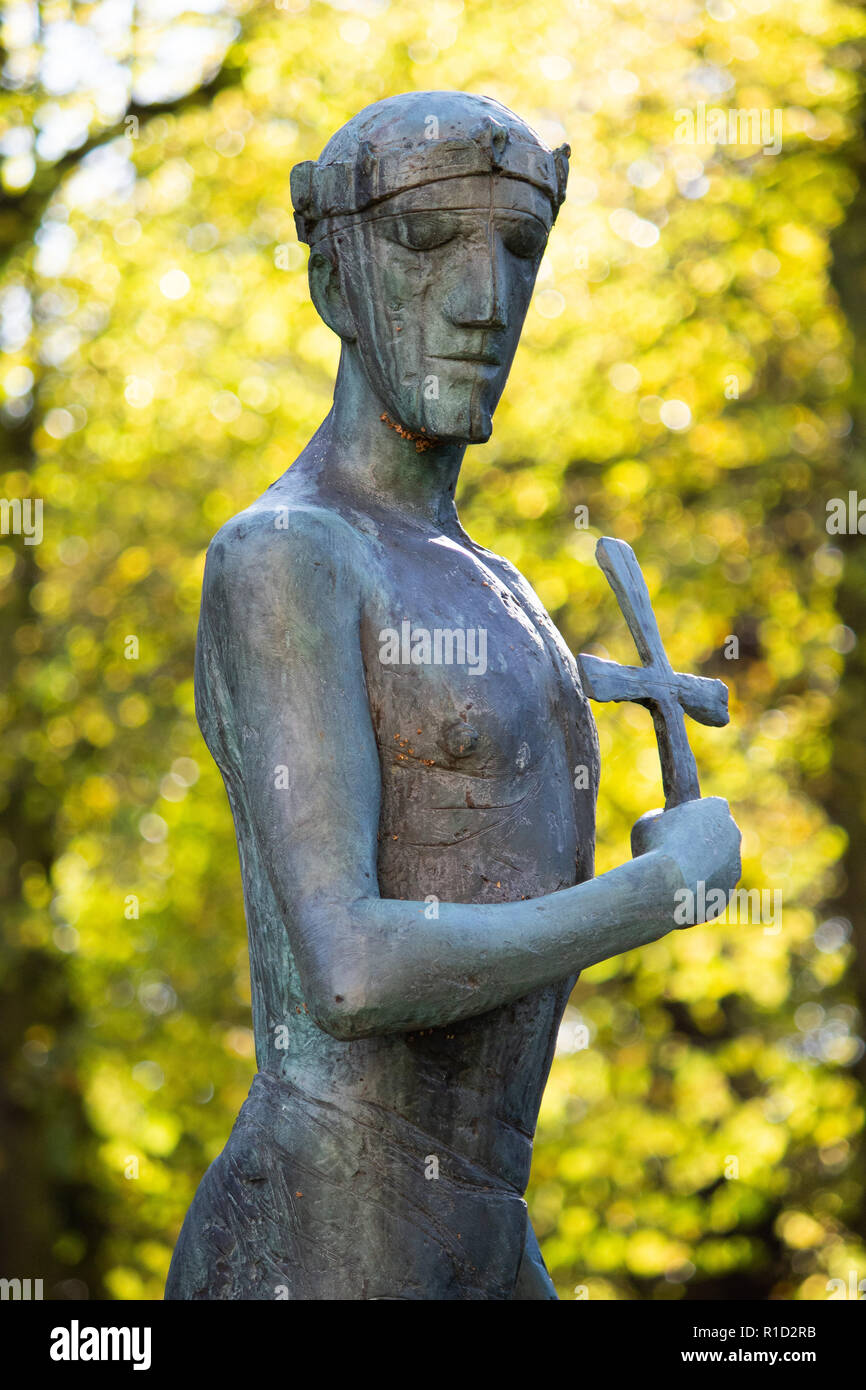 Bronze statue of King Edmund as a young man with a cross in his hand by Elisabeth Fink in the Cathedral grounds, Bury St Edmunds, Suffolk Stock Photo