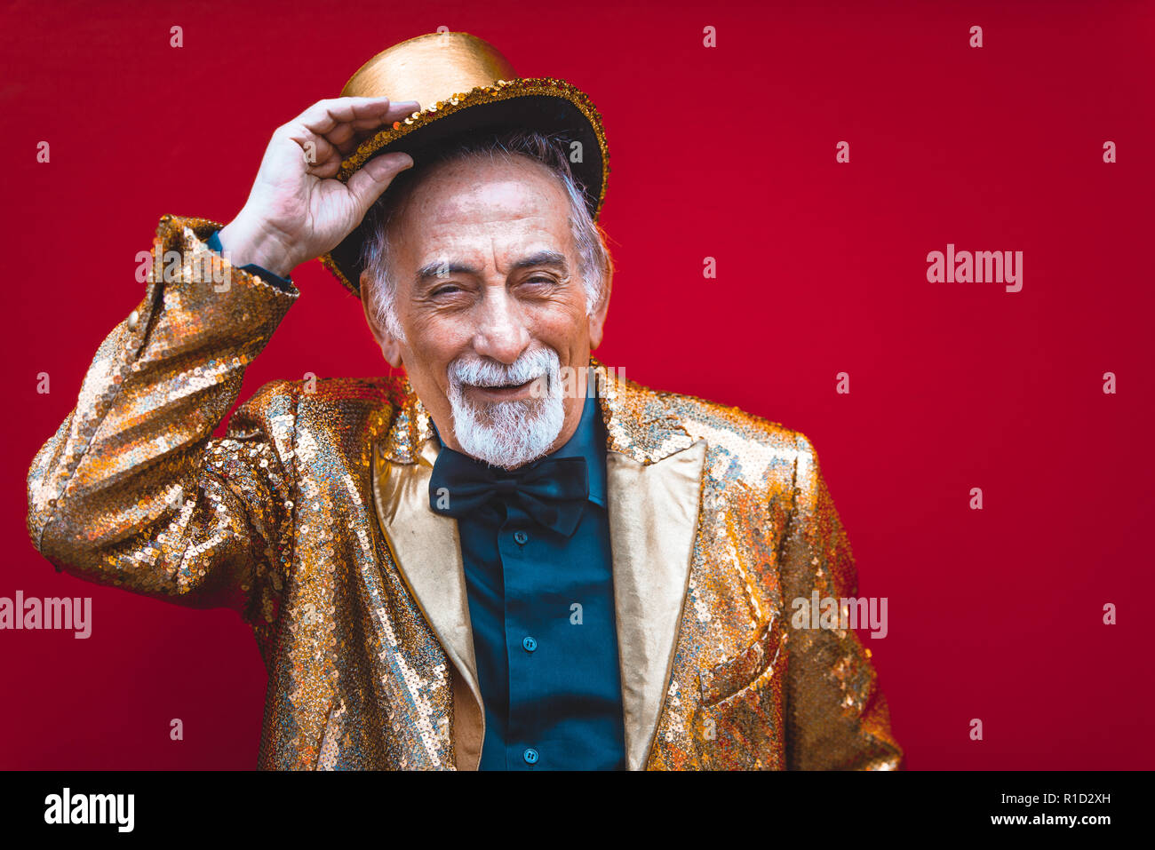 Funny And Extravagant Senior Man Posing On Colored Background