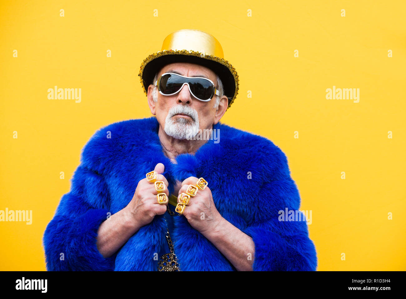 Funny And Extravagant Senior Man Posing On Colored Background