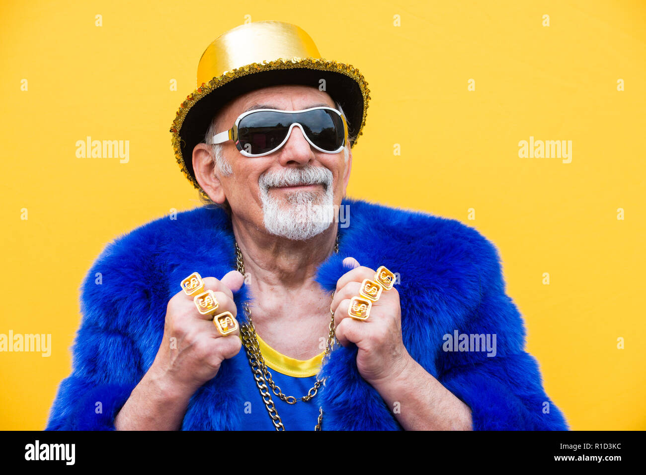 Funny And Extravagant Senior Man Posing On Colored Background