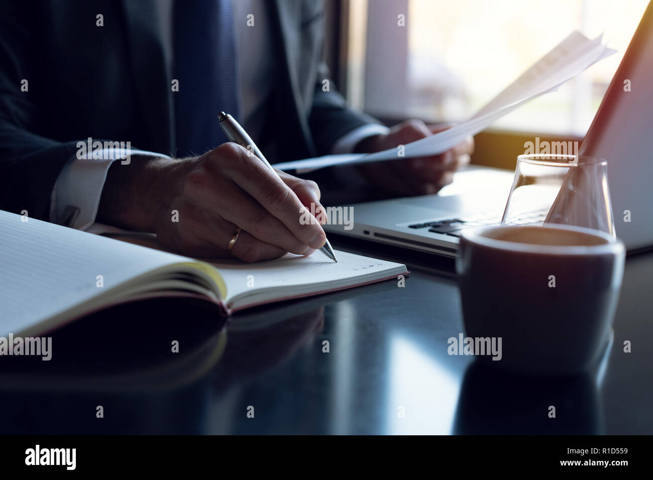Businessman analyzing investment charts. Accounting. Hands of financial manager taking notes while working. Stock Photo