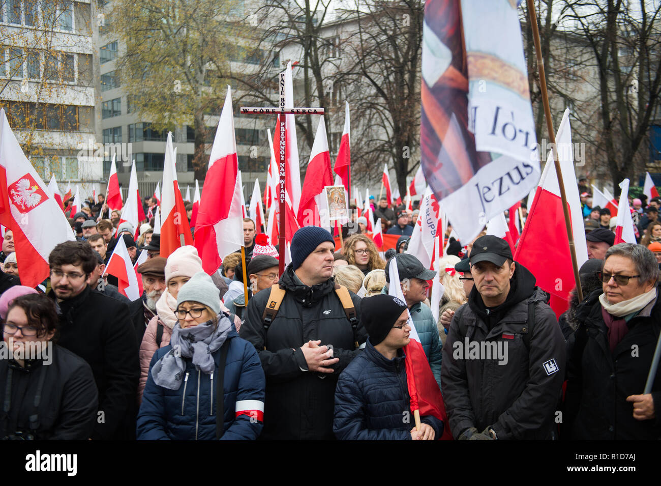 Members of the National Radical Camp (ONR) and the conservative right wing associations are seen holding flags while praying next to the Polish Parliament before the official march. Days before the Independence Day, the mayor of warsaw, Hanna Gronkiewicza banned the Independence Day march organized by the extreme right wing associations while on the same day, the Polish government announced a state march that would depart from the same place as they banned the Independence Day march. On November 09th The Polish government and the organizers of the march of nationalists agreed to hold a joint m Stock Photo