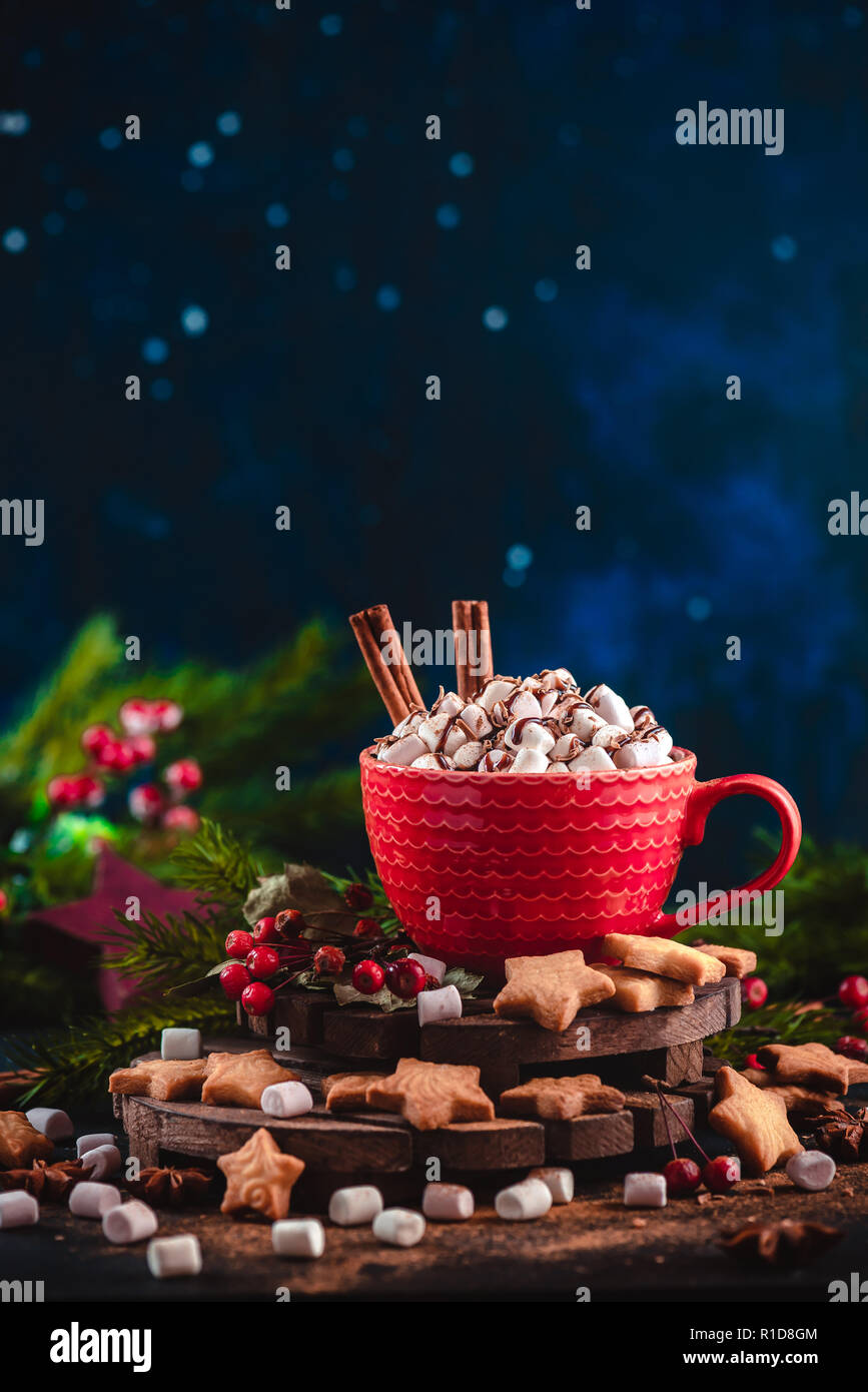 Christmas hot chocolate with marshmallows, chocolate crumbs, and syrup. Large coffee cup with homemade cocoa. Winter drink photography on a dark backg Stock Photo