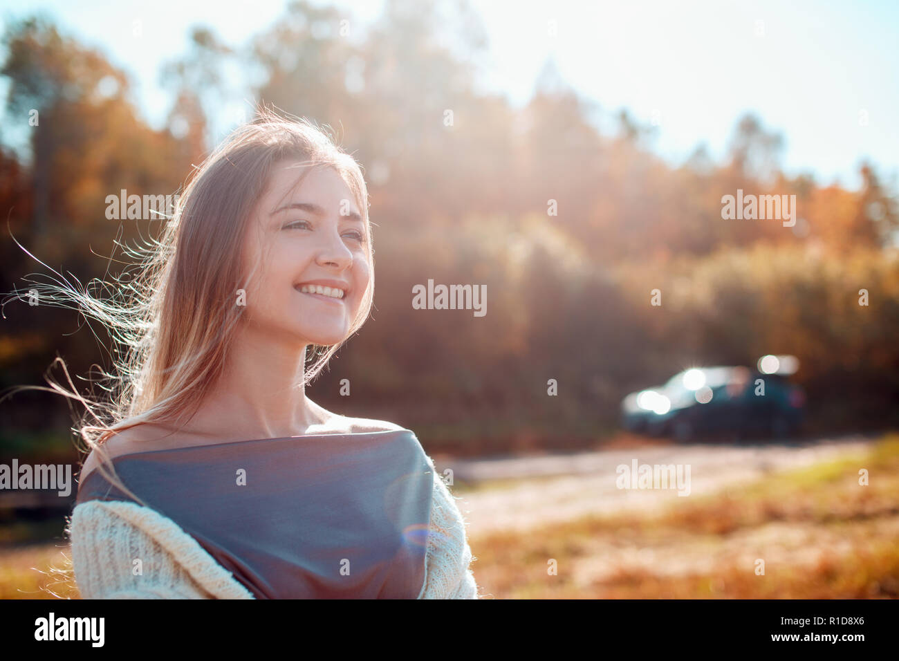 Pretty girl posing on camera and enjoying sunny autumn day. Stock Photo