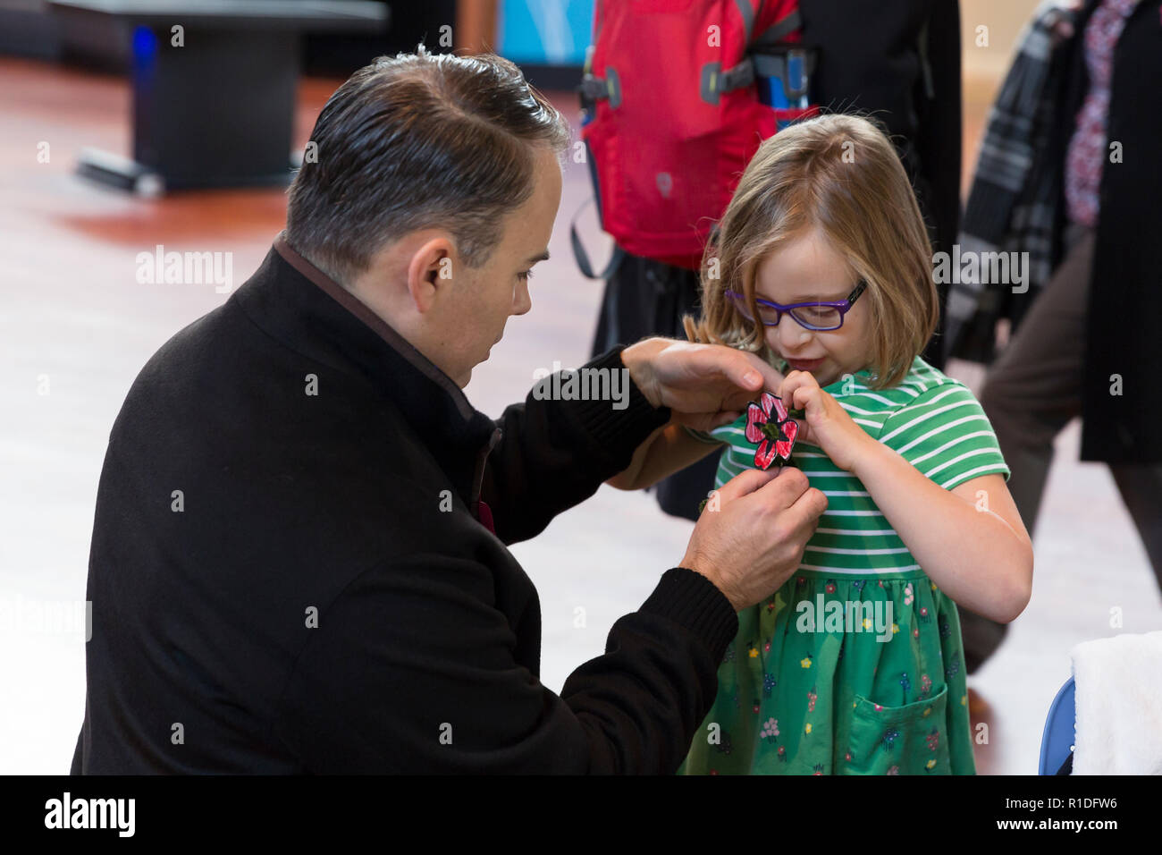 Seattle, Washington: Scott pins a remembrance poppy on his six-year-old daughter, Audrey, at the Armistice Day Centennial Commemoration at the Museum of History & Industry. The ceremony marked the centennial of the Armistice of 11 November 1918 ending World War I. In attendance were representatives from the Consulates of Austria, Canada, Finland, Germany, Hungary, Lithuania, Turkey, the United Kingdom, and others. Credit: Paul Christian Gordon/Alamy Live News Stock Photo