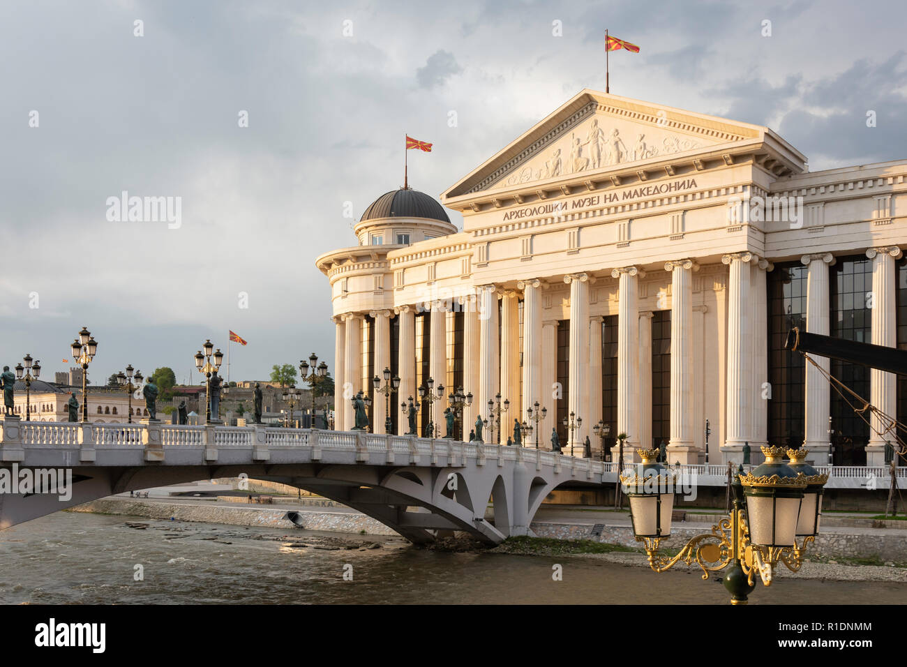 The Museum of Archaeology and Bridge of Civilization across River Vardar at sunset, Skopje, Skopje Region, Republic of North Macedonia Stock Photo