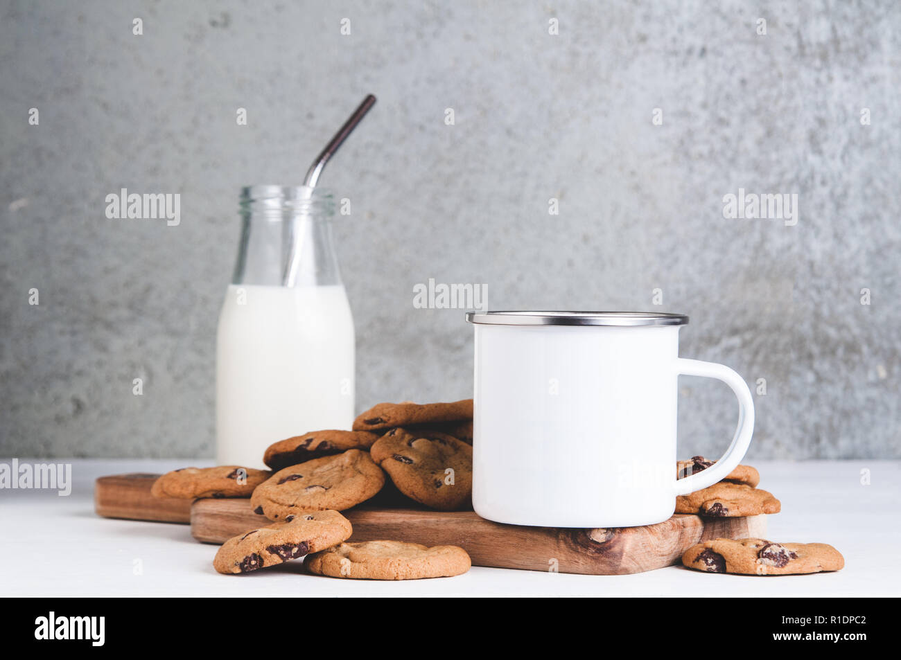 10oz white metal camp mug mock up with milk and cookies Stock Photo