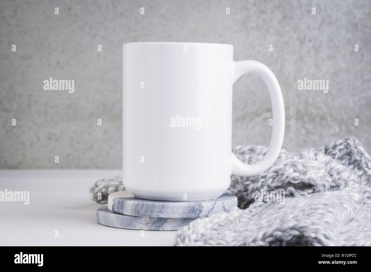 15 oz mug mockup with marble coasters and a grey blanket Stock Photo