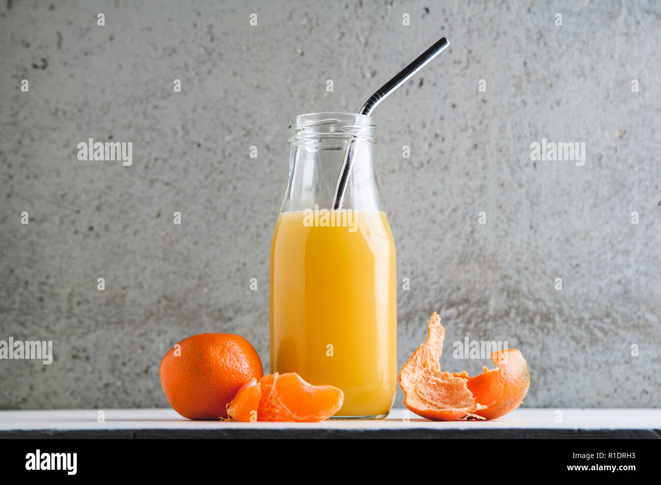 orange juice in a bottle with a reusable metal straw Stock Photo