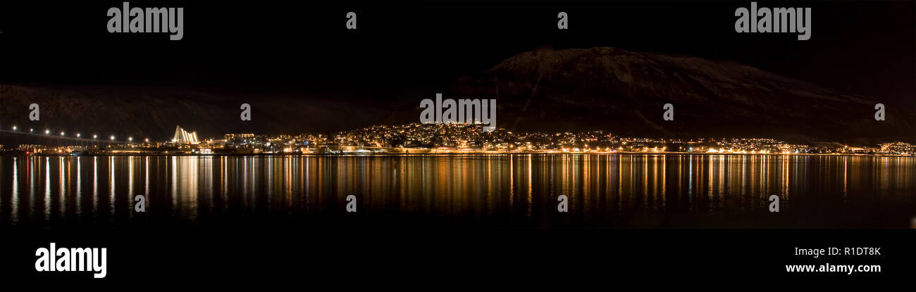 A panoramic night view of Tromsdalen from Tromsø, including sight of the Arctic Cathedral and with the mountains just visible in the background. Stock Photo