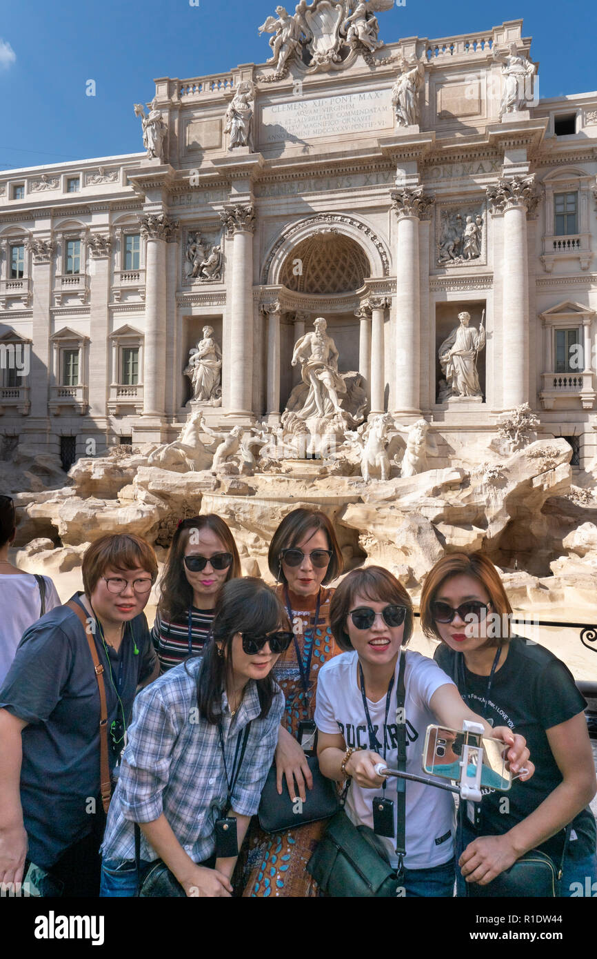 Tourists taking a group selfie photograph in front of the Trevi Fountain, Rome, Italy. Stock Photo