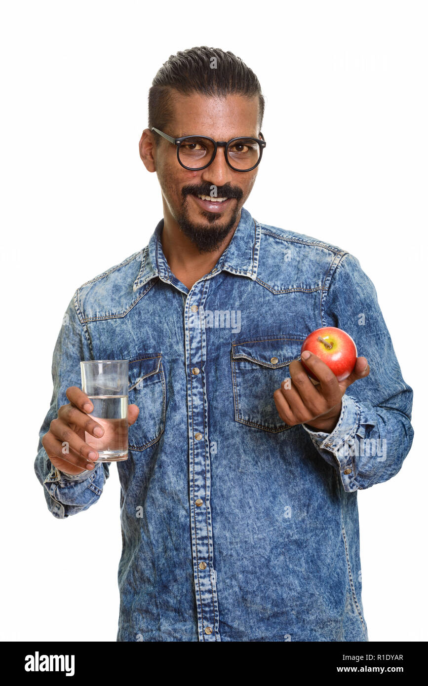 Young happy Indian man holding red apple and glass of water Stock Photo ...