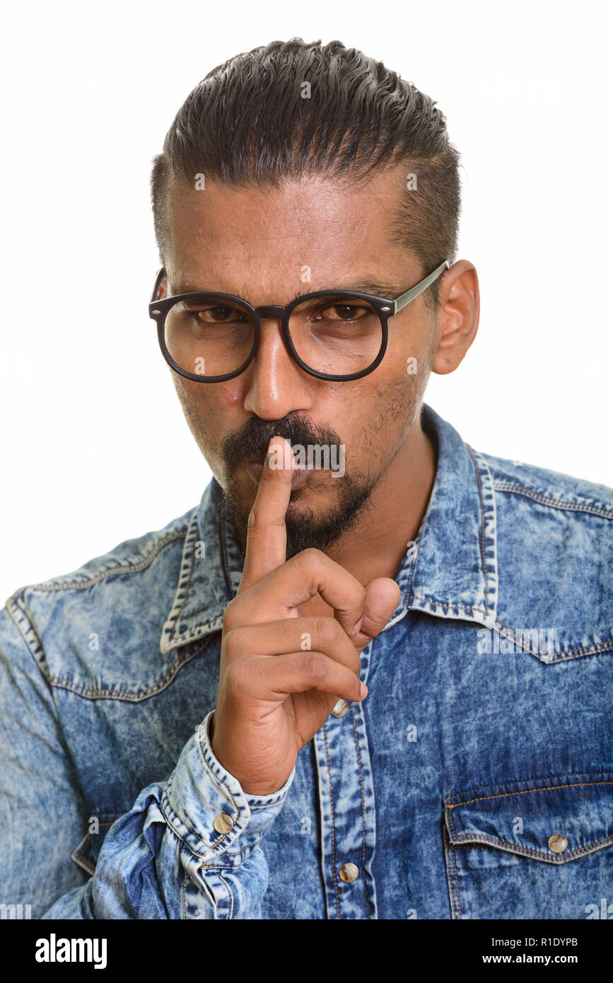 Young Indian man with finger on lips Stock Photo