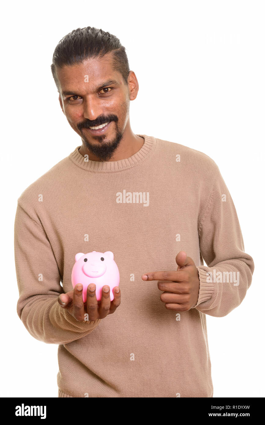 Young happy Indian man holding piggy bank and pointing finger Stock ...