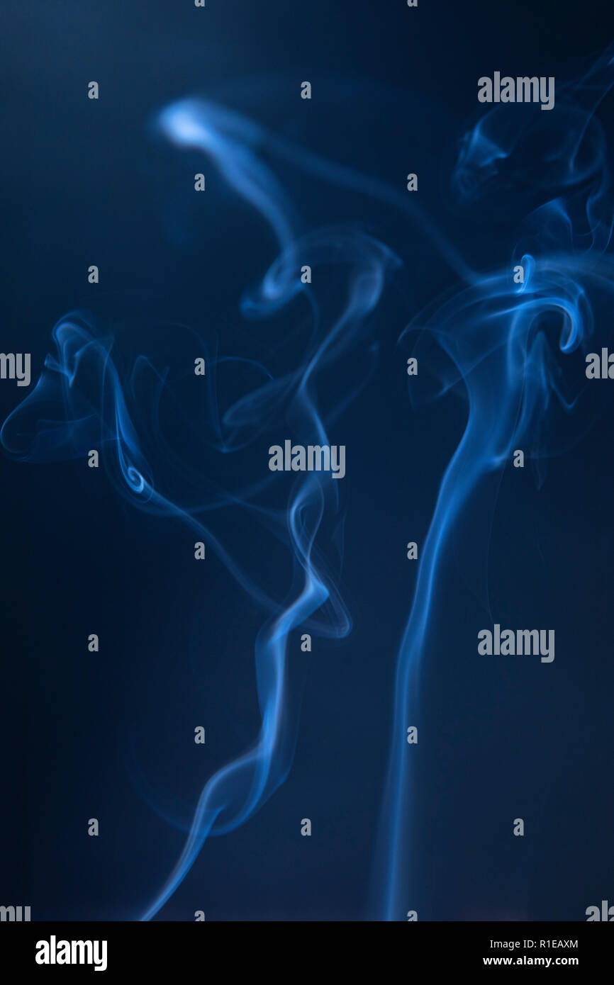 Abstract blue smoke swirls on dark background Stock Photo - Alamy