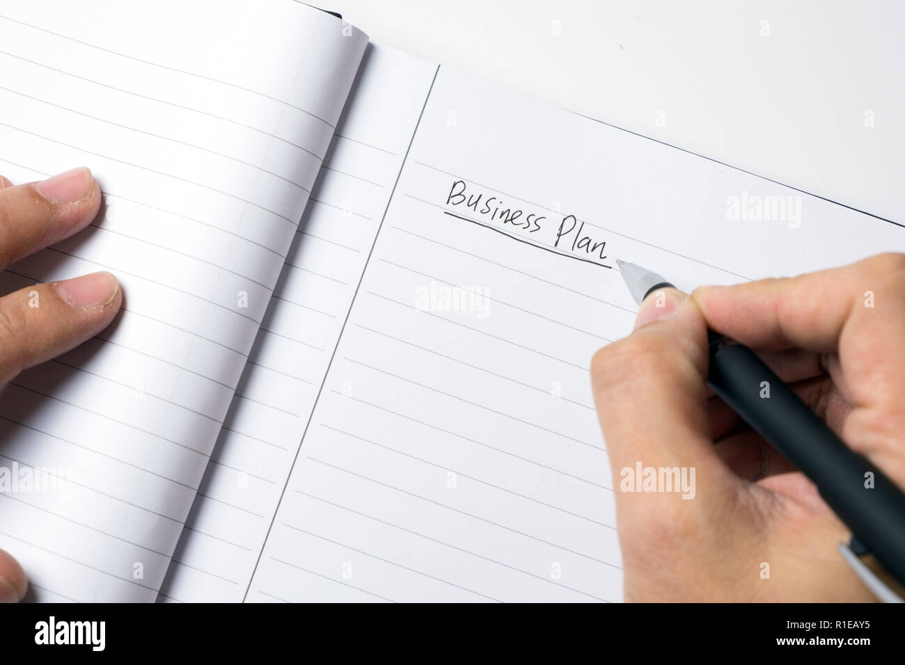 Close-up of male hand writing down business plan Stock Photo