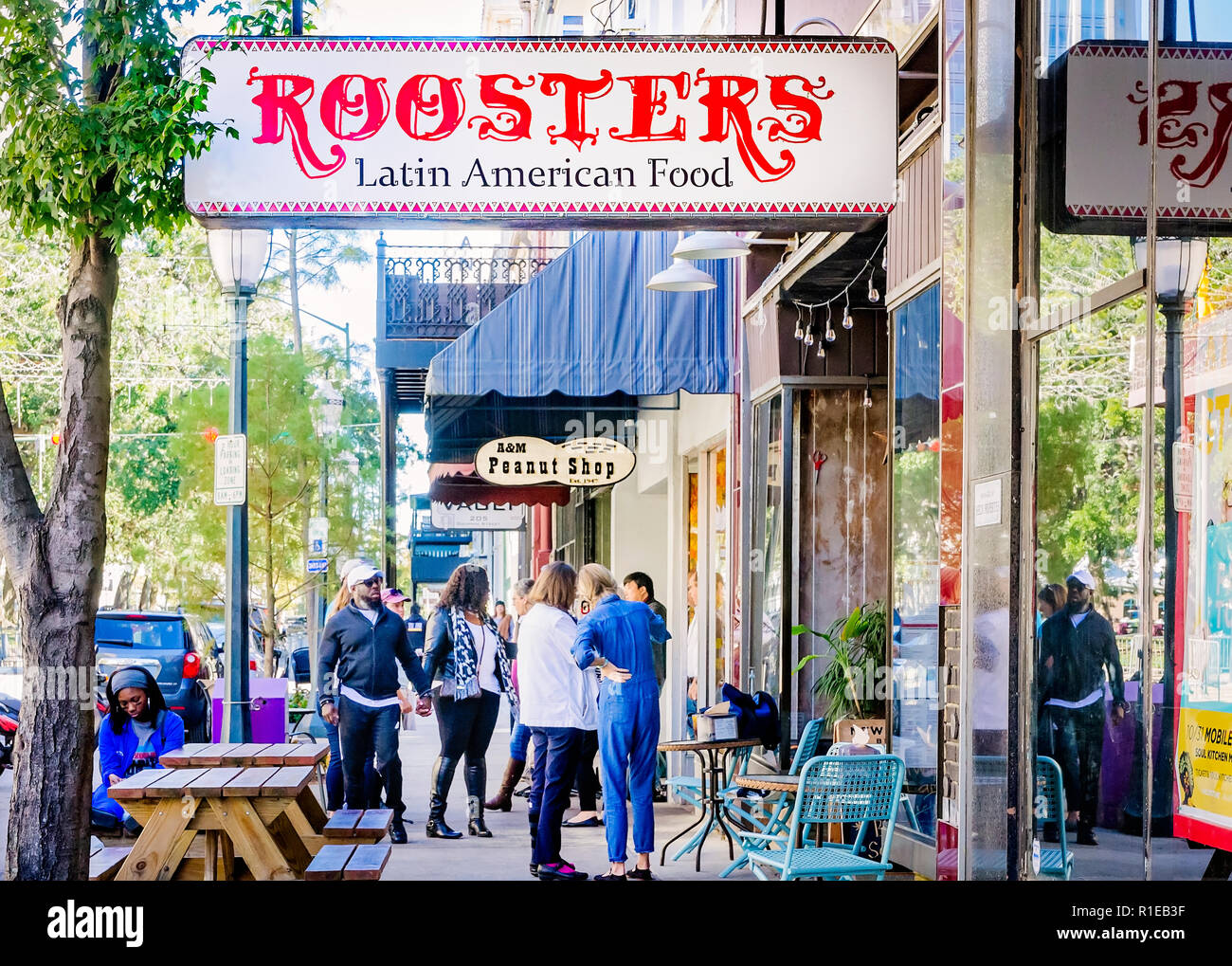 Tourists gather in front of Roosters Latin American Food and A&M Peanut Shop on Dauphin Street, Nov. 3, 2018, in Mobile, Alabama. Stock Photo