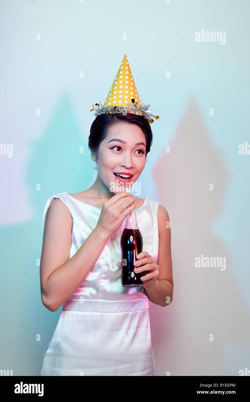 Portrait of beautiful happy cute asian woman in casual dress isolated on white, drinking cola from bottle with straw Stock Photo