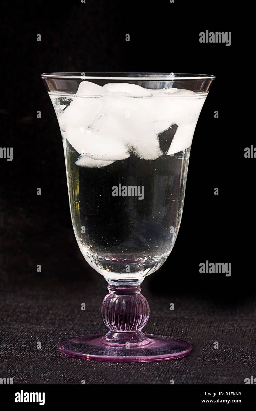 Glass of water with ice close-up. on either black background or our ...