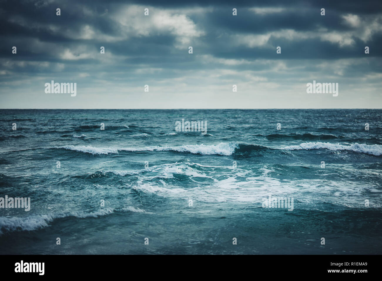 Water waves on cloudy sky background. Stock Photo