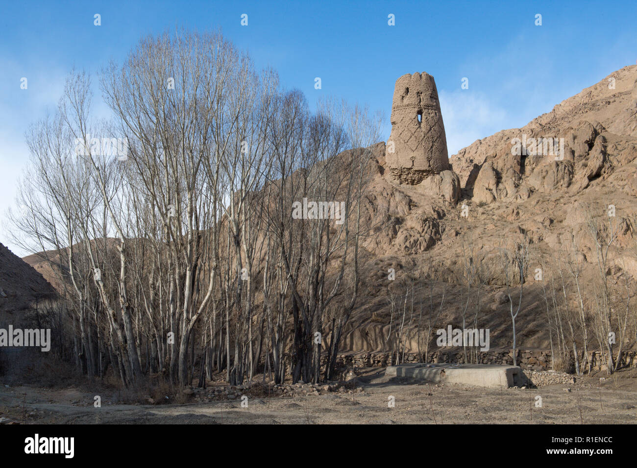 Remains Of Fortified Tower On A Hill With Leafless Trees In The Foreground Near Bamyan In Winter, Bamyan Province, Afghanistan Stock Photo