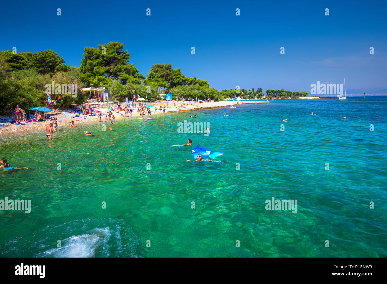 BRAC, CROATIA - August 6, 2018 -Pebble beach on Brac island with turquoise clear ocean water, Supetar, Brac, Croatia Stock Photo