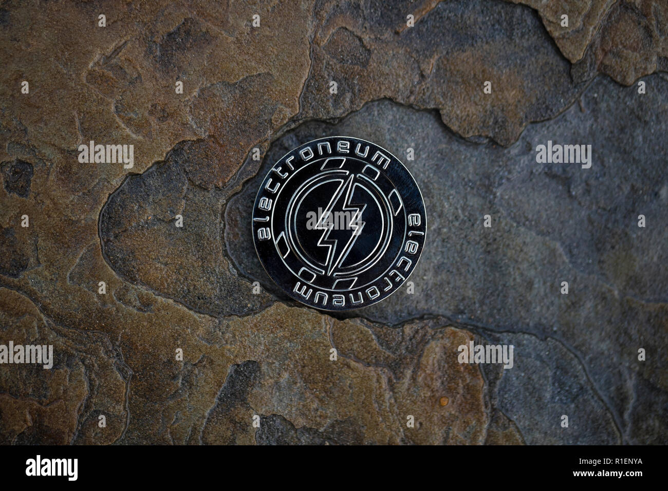 Electroneum cryptocurrency physical coin placed on stone floor Stock Photo