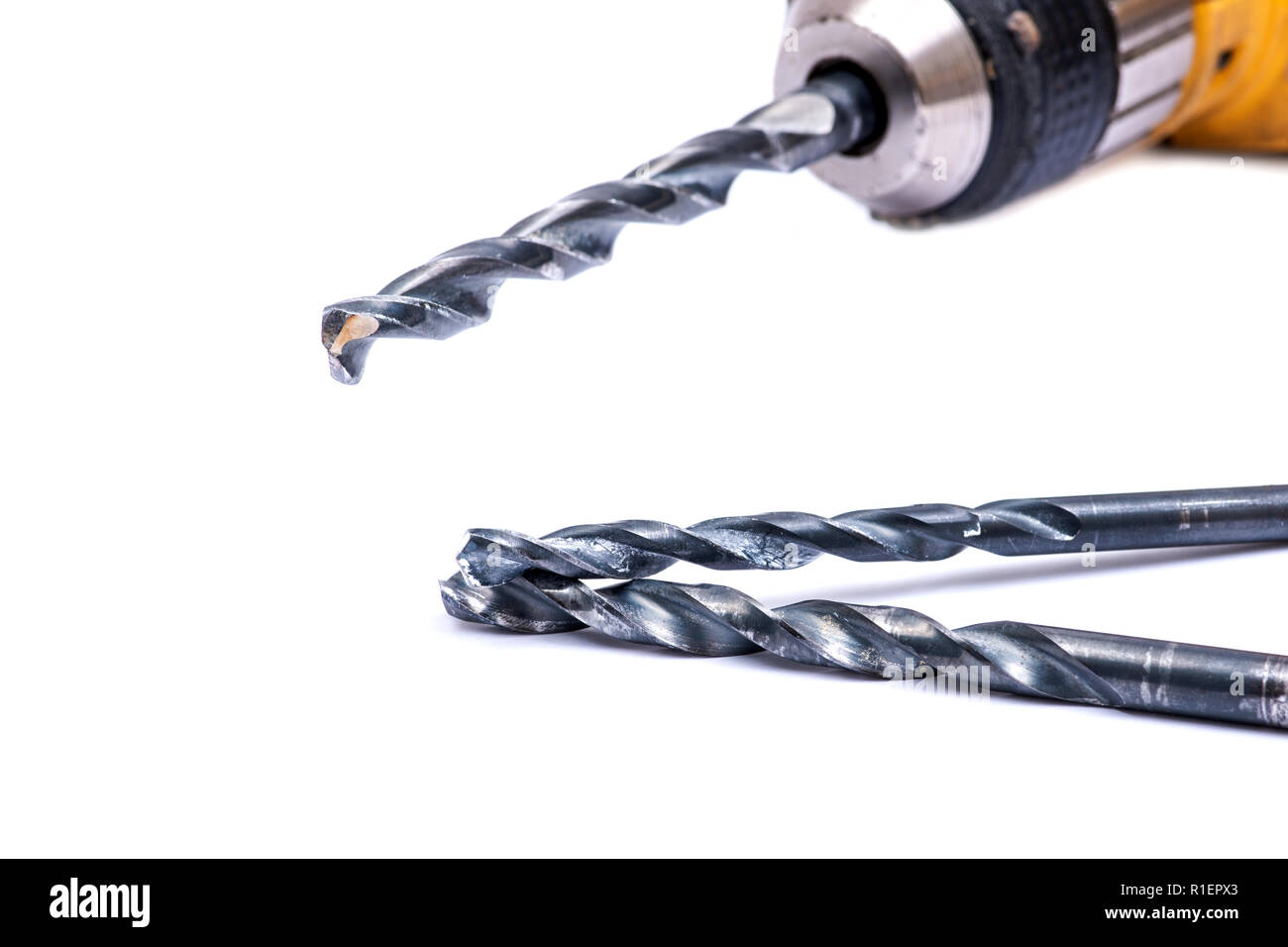 Old drill gun with used drill bit isolated on white background Stock