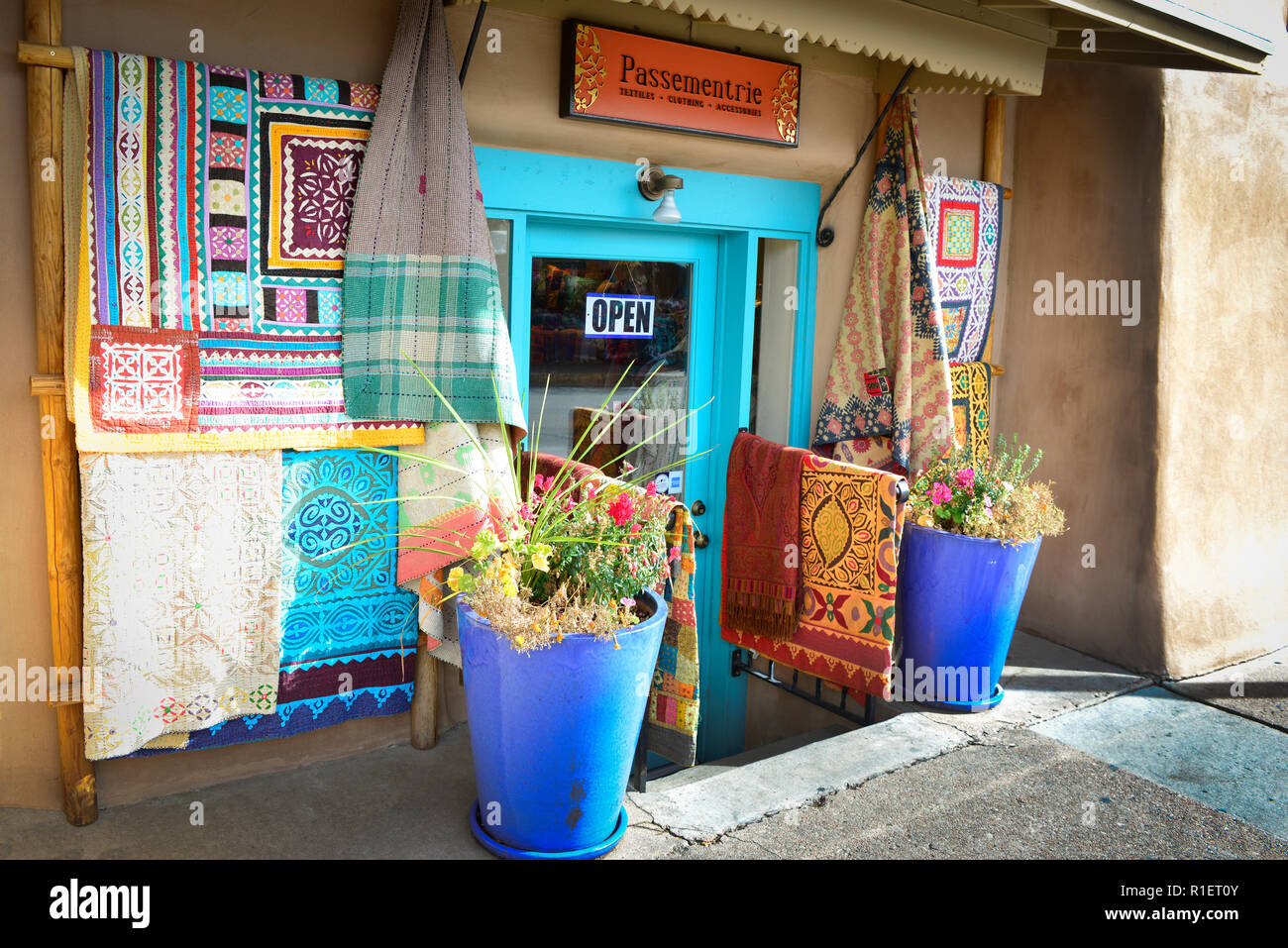 A textile shop displaying their colorful wares outside their entrance in historic downtown Santa Fe, NM Stock Photo